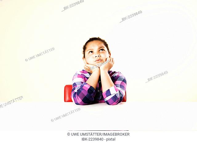 Girl sitting and thinking at a table