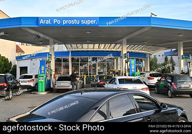 02 October 2023, Poland, Slubice: Only vehicles from Germany are parked at the Aral service station in Slubice, Poland, to fill up on diesel or gasoline at low...