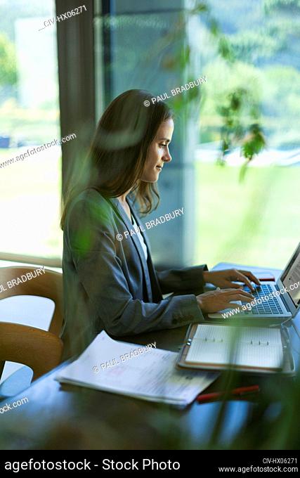 Focused businesswoman working at laptop