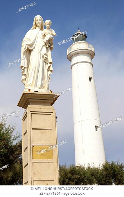 Statue of Mary holding Jesus, and the lighthouse, Punta Secca, Santa Croce Camerina, Sicily, Italy
