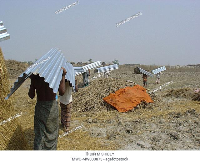 Workers carrying tin slats Gaibandha Bangladesh