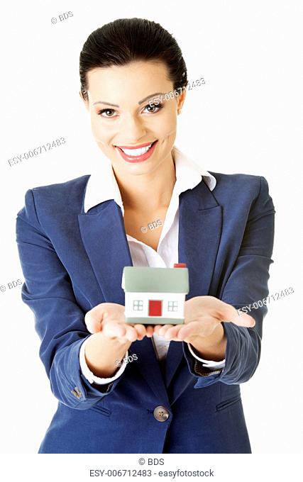 Beautiful young businesswoman holding house model over white - real estate loan concept