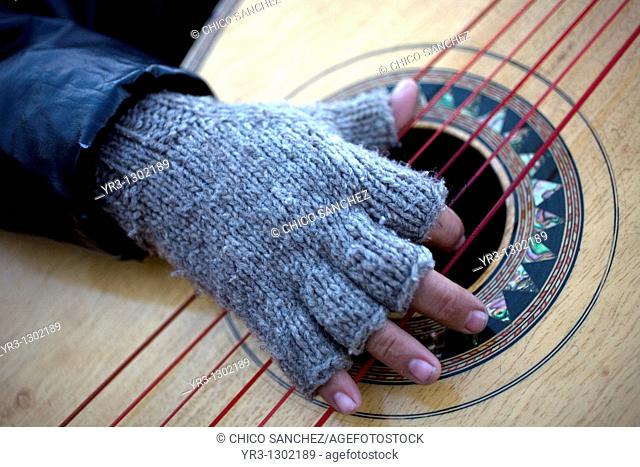 A man wearing wool gloves play the guitar outside of the Our Lady of Guadalupe Basilica, Mexico City, December 6, 2010  Hundreds of thousands of Mexican...