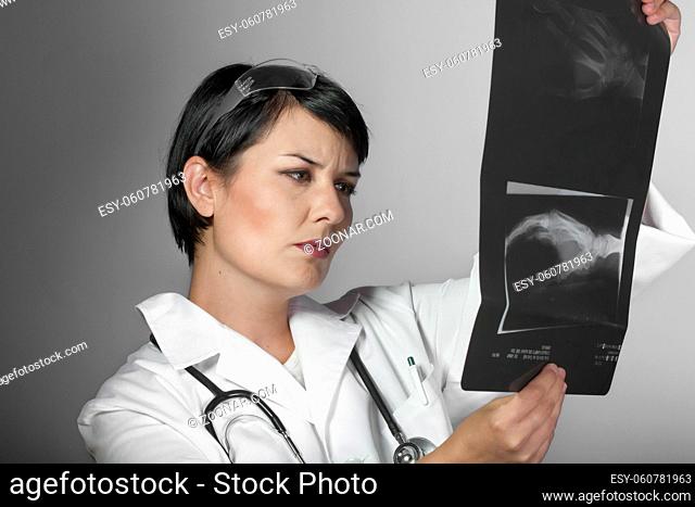 Portrait of an attractive young female doctor in white coat. Smiling medical woman doctor. Isolated over white background