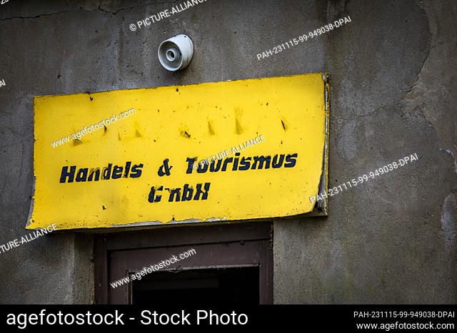 PRODUCTION - 08 November 2023, Mecklenburg-Western Pomerania, Flessenow: A weathered sign with the inscription ""Handels & Tourismus GmbH"" hangs above the...