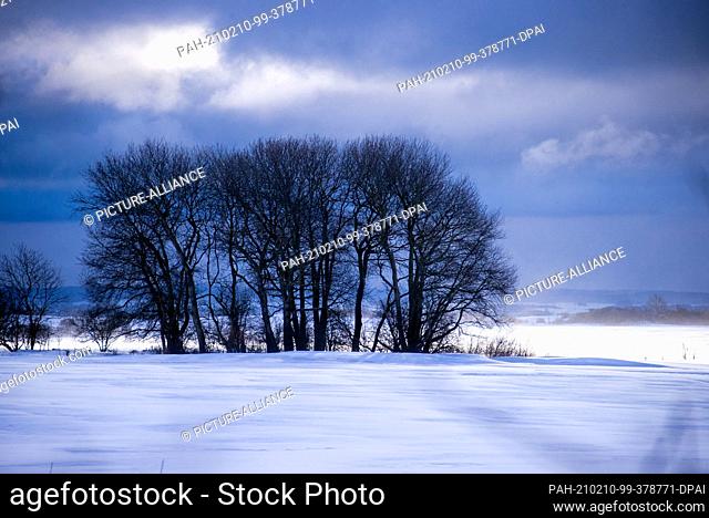 10 February 2021, Mecklenburg-Western Pomerania, Putgarten: Dark snow clouds drift across the snowy landscape near the village of Putgarten in the north of the...