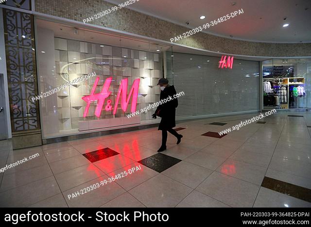 03 March 2022, Russia, St. Petersburg: A woman walks past a closed H&M in a shopping center in St. Petersburg. Swedish fashion giant H&M suspends its sales...