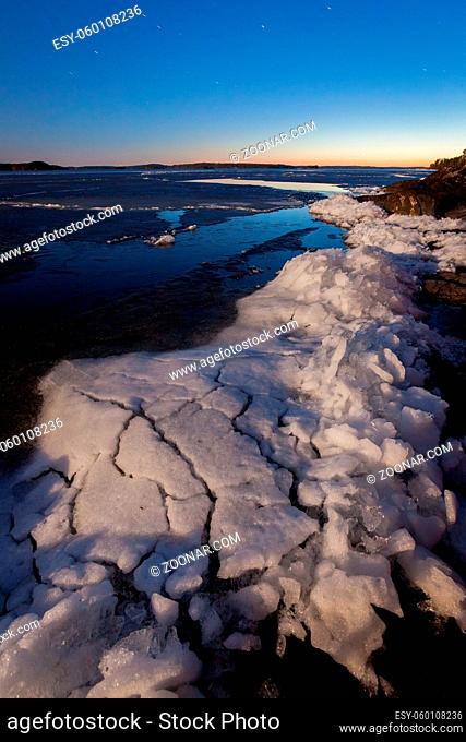 Partially melting ice in lake at night landscape