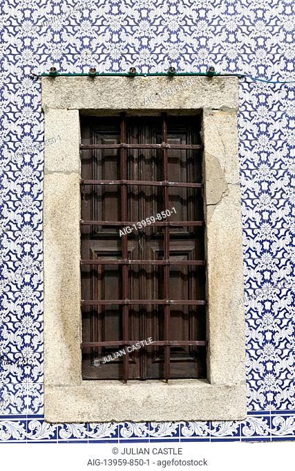 An ancient iron-barred window surrounded by decorative azulejo tiles, Ovar, Beira Litoral, Portugal