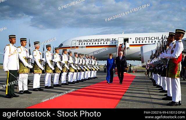 16 February 2023, Malaysia, Kuala Lumpur: German President Frank-Walter Steinmeier (r) and his wife Elke Büdenbender (l) are welcomed by a guard of honor on...