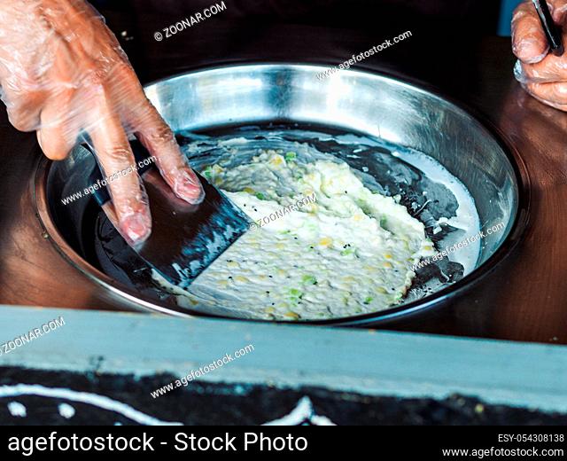 Making rolled ice cream. Man hands making kiwi and banana Thay style natural ice cream
