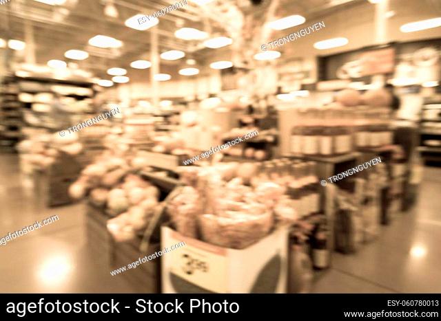 Vintage tone blurred image Halloween decoration inside grocery store in Houston, Texas, USA. Pile of pumpkins on hay, corns