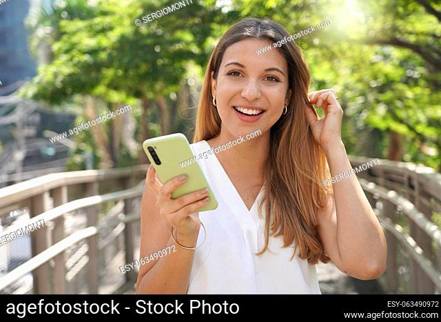 Close-up of beautiful business woman holding smartphone looking at camera