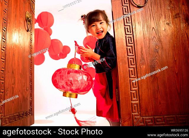 Beautiful little girl hand red lanterns to celebrate the New Year