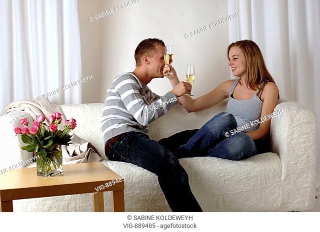 Young couple sitting on a sofa and drinking sparkling wine. - 30/06/2008