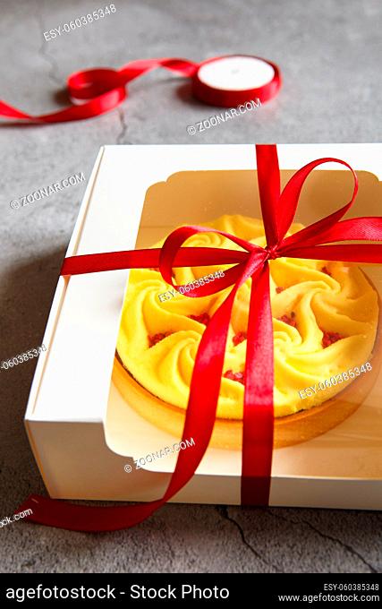 Delicious yellow tart in the gift box. Tasty and colorful dessert - lemon curd tart made by pastry chef