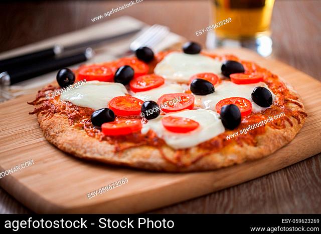 Pizza with Fresh Cheese, Cherry Tomatoes and Olives and Beer