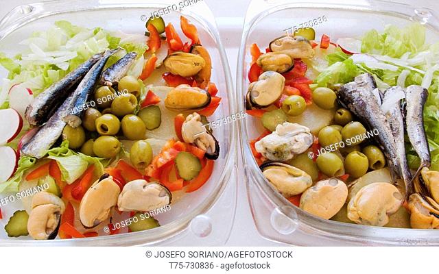 Salad with sardines, cooked potato, mussels, lettuce, olives, onion, pepper, radishes and cucumber
