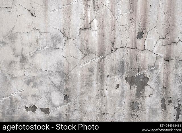 Plaster falling off of an old wall. Old cracked and ruined wall with cracks on plaster. Grunge Background