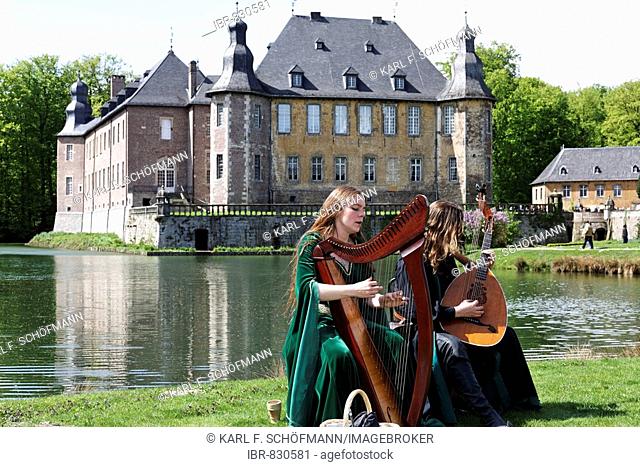 Two musicians in medieval costume playing a Celtic harp and a lute during the Renaissancefest or Renaissance Festival at the moated castle Wasserschloss Dyck