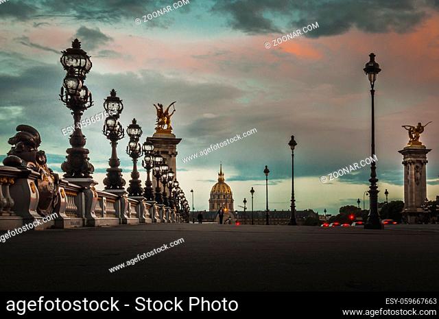 View of the Alexandre III bridge under a dark sunset in Paris