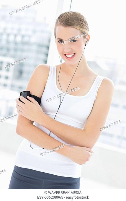 Smiling sporty woman changing song on her mp3