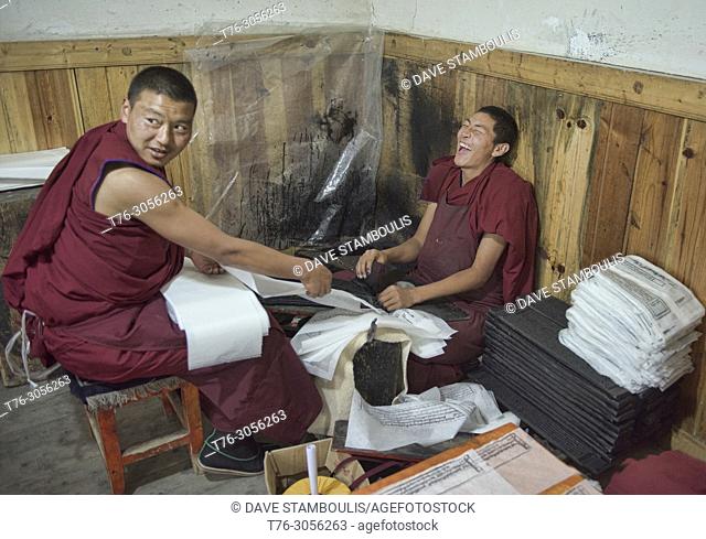 Monks making handmade paper scriptures and woodblock prints inside the holy Bakong Scripture Printing Press Monastery in Dege, Sichuan, China
