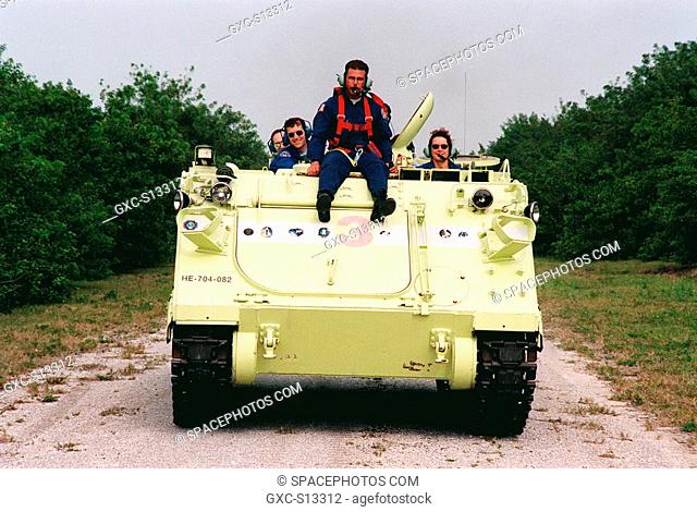 04/27/1999 --- STS-96 Mission Specialist Julie Payette right practices driving a small armored personnel carrier that is part of emergency egress training...