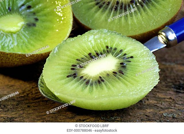 Kiwi fruit, one half on a spoon