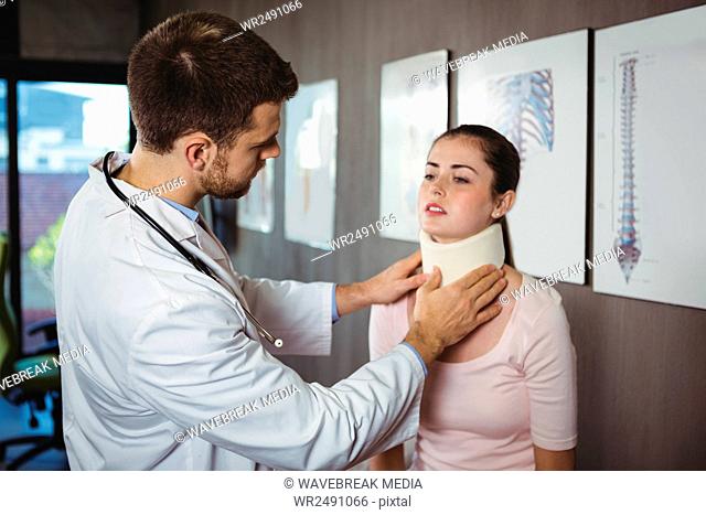 Physiotherapist examining a female patient's neck