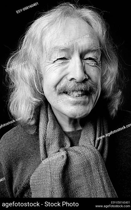 Studio shot of senior man with mustache wearing warm clothing against gray background
