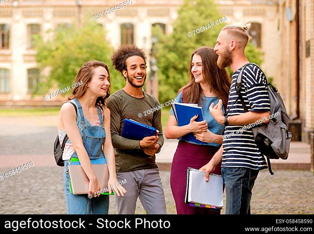 College students going to classes, talking and laughing. Friends meeting in campus before classes