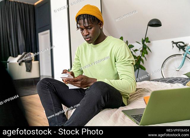 Businessman calculating financial bill in bedroom