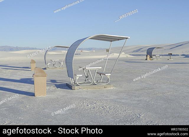 Shelters and trash bins among gleaming white sand dunes