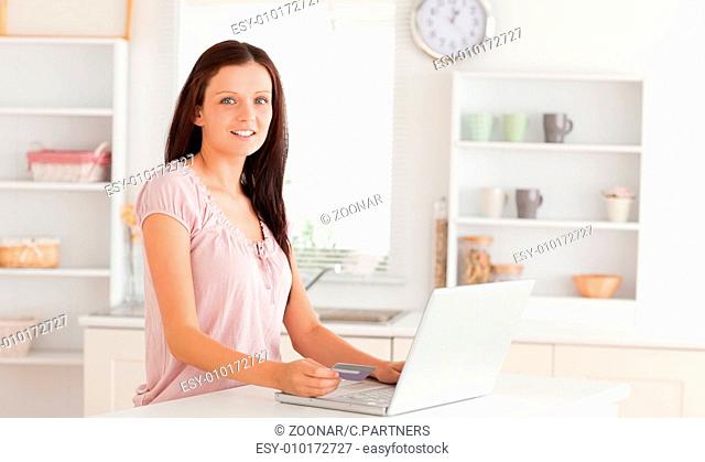 Woman with credit card and laptop looking