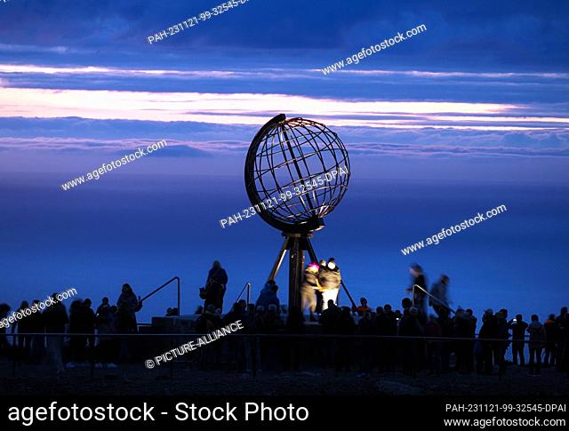 24 August 2023, Norway, Nordkapp: In the early morning, tourists visit the globe on the North Cape's slate plateau, which is located around 300 meters above the...