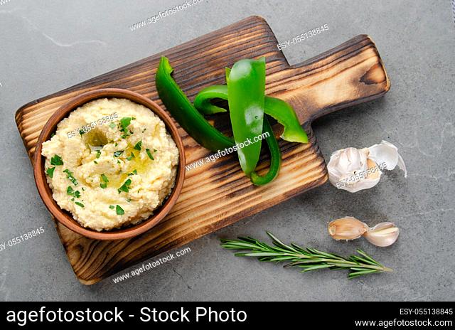 Flat lay view at vegetable Hummus dip dish topped with olive oil served with green sweet bell pepper slices