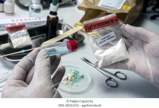 Police scientist holds drug-positive swab, crime lab, concept image