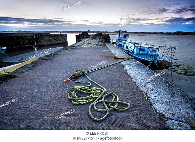 Beadnell Harbour at dusk showing old rope coiled on harbourside and dilapidated fishing boat, Beadnell, Northumberland, England, United Kingdom, Europe