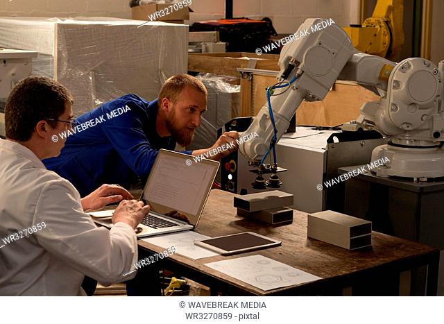 Robotic engineers examining robotic machine