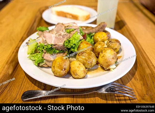Hearty lunch. A plate with young potatoes and meat is standing on a tray with coffee and juice. Morning tomorrow. Refusal of a healthy lifestyle