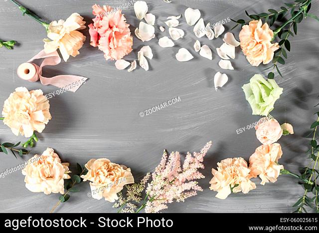 flowers and garden tools. The florist work table with accessories gray wooden background