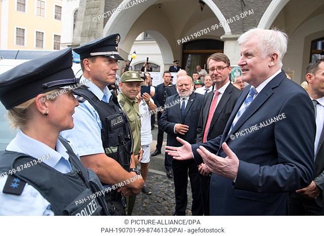 01 July 2019, Saxony, Görlitz: Federal Interior Minister Horst Seehofer (CSU, r) talks with German and Polish policemen on the submarket