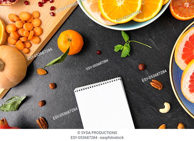 close up of notebook, fruits and vegetables