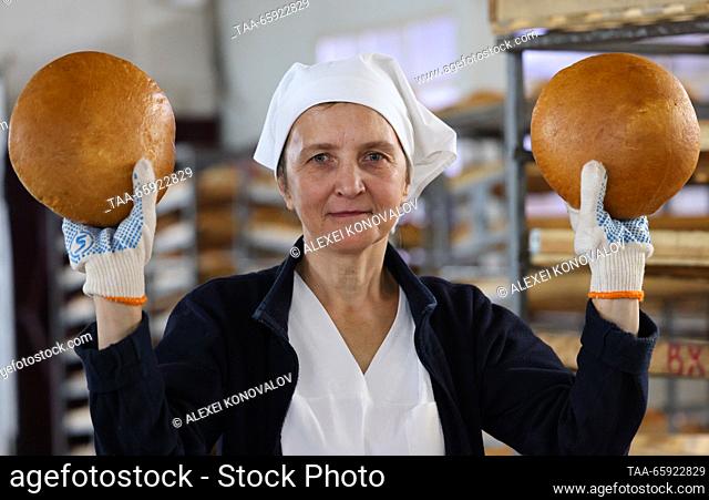 RUSSIA, ZAPOROZHYE REGION - DECEMBER 19, 2023: An employee holds freshly baked loaves of bread at the Berdyansk Bakery in the city of Berdyansk