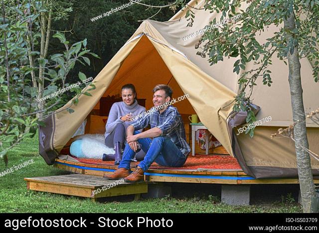 Young couple drinking wine in tent