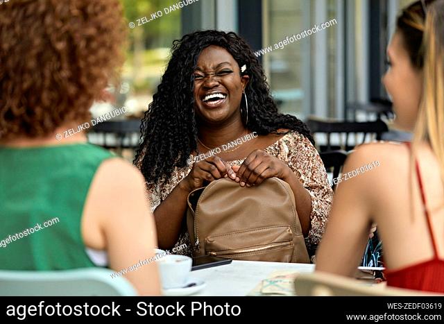 Happy female friends meeting in a cafe