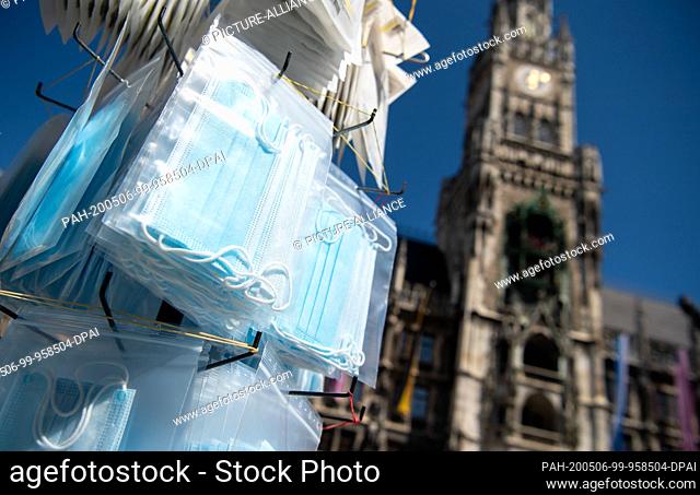 06 May 2020, Bavaria, Munich: A souvenir stand on the Marienplatz offers mouthguards. In the background you can see the town hall