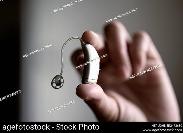 Hand holding hearing aid