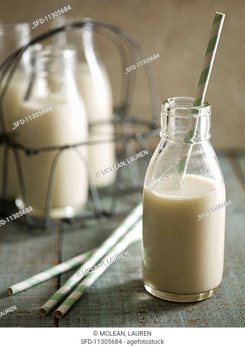 Almond milk in a glass bottle with a straw